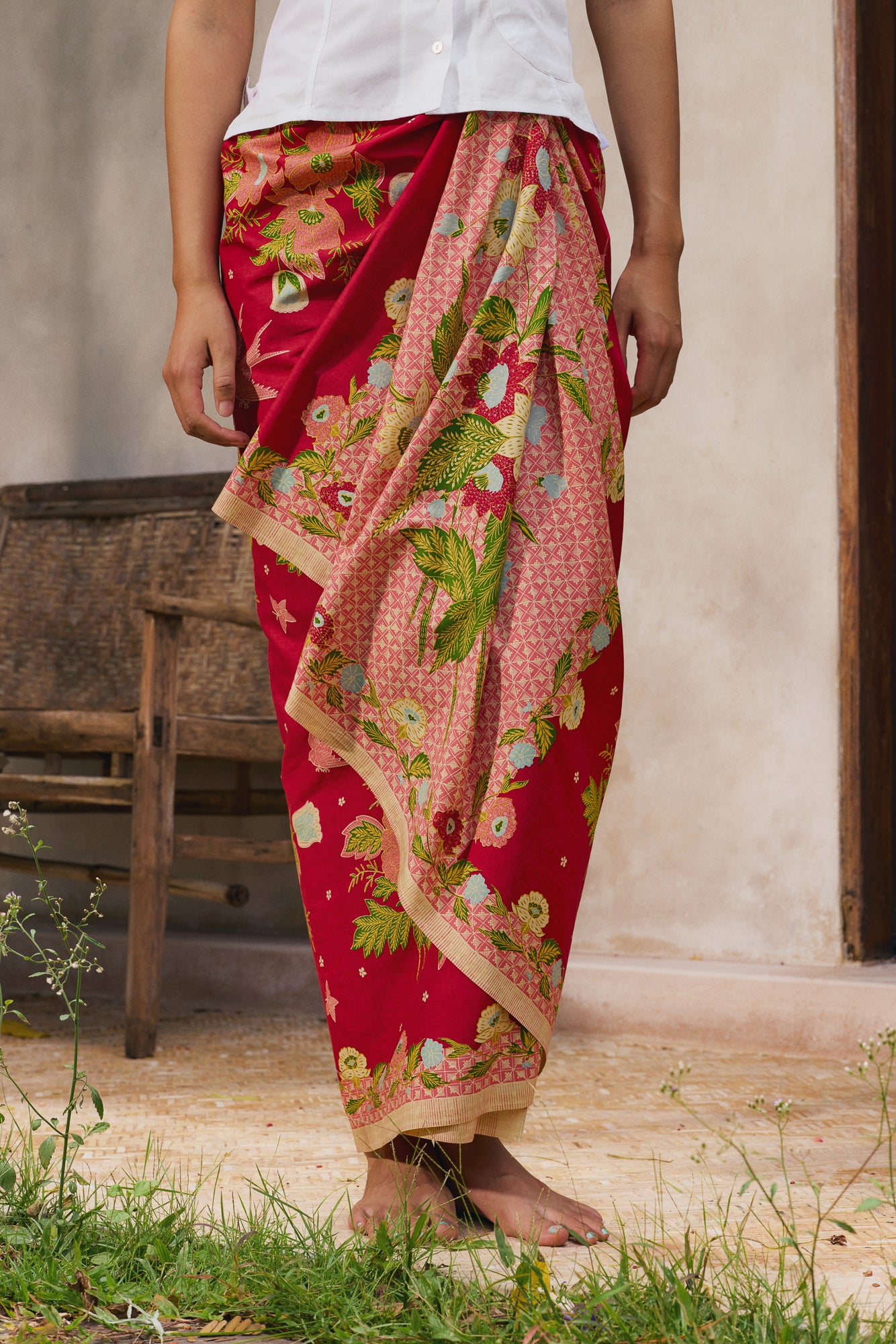 Old batik motif with pink flowers green leaves birds and butterfly on a red background, sarong styling